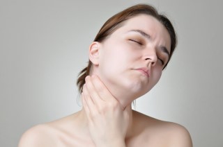 woman holding her throat in pain