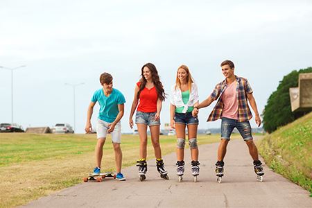 Four teens rollerblading outside